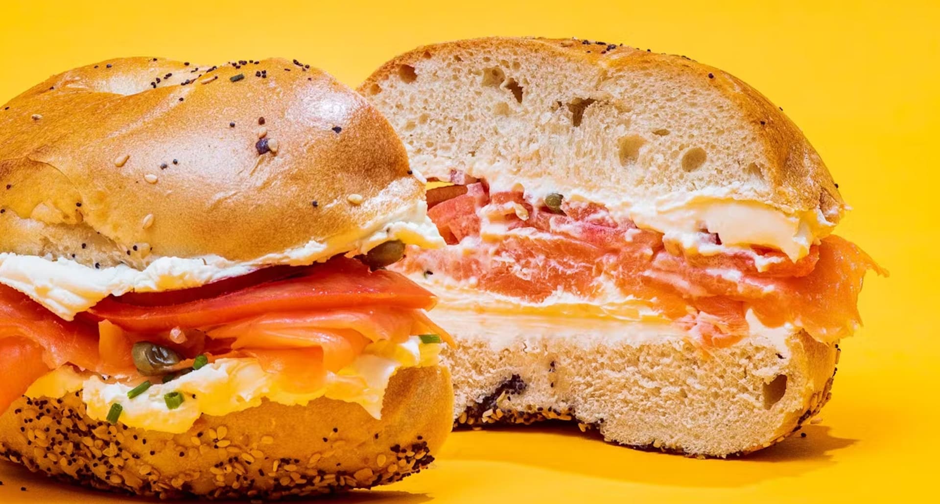 best bagels in nyc: lox and cream cheese bagel on yellow background