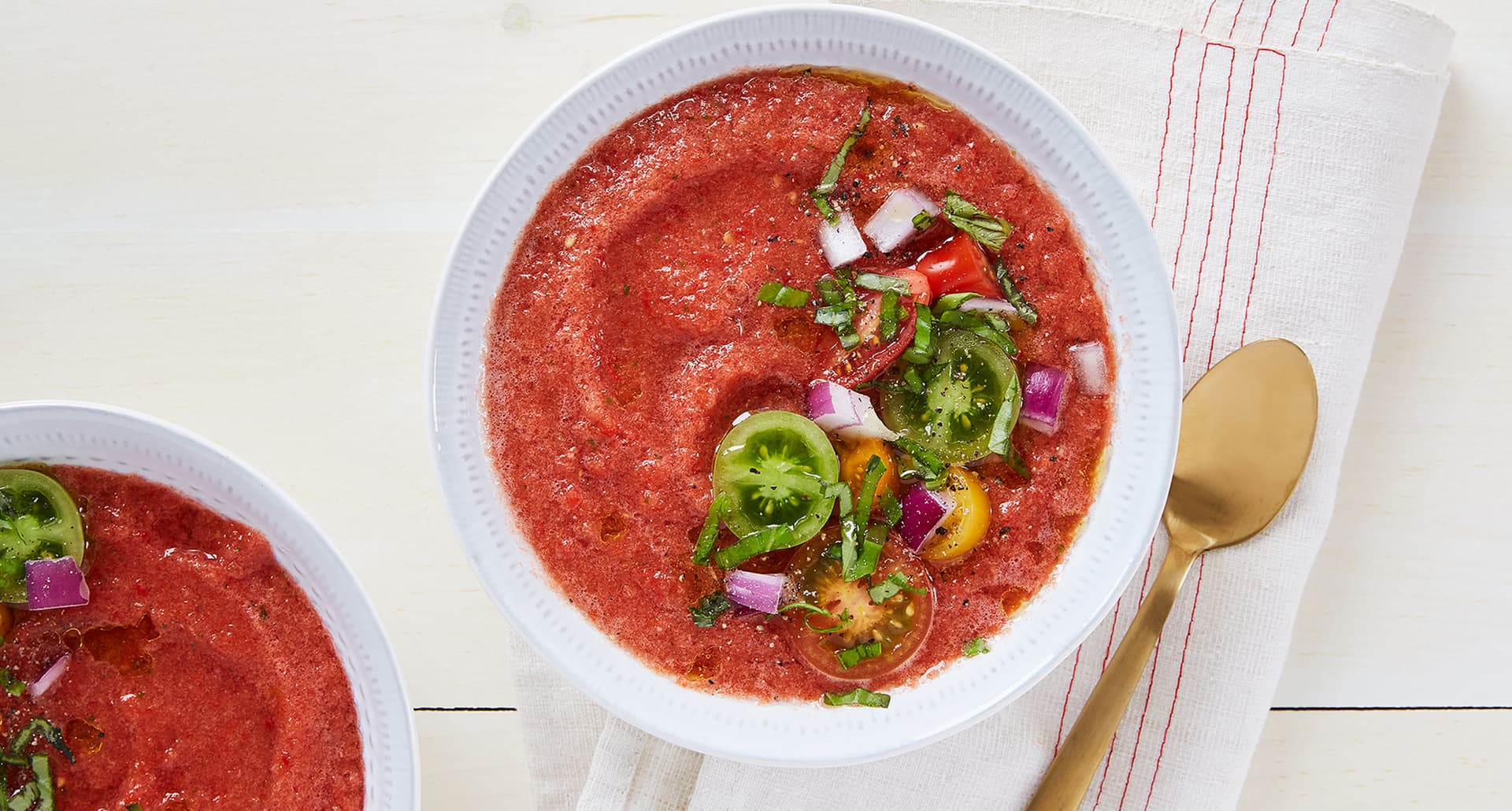 no cook dinners for summer: bowl of 15-minute tomato gazpacho on a counter top next to a linen napkin and spoon
