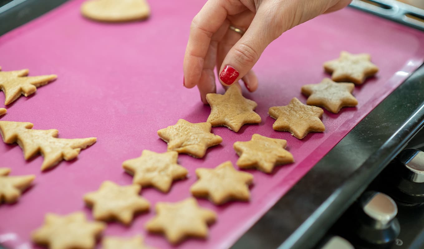 Best silicone baking mat: A woman places star-shaped cookies on a silicone baking mat