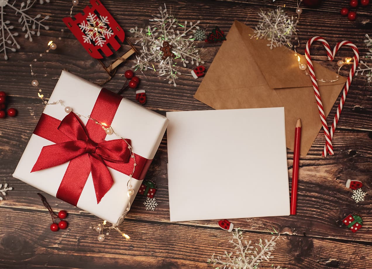holiday-quotes: a present, a letter, and two candy canes under a tree.