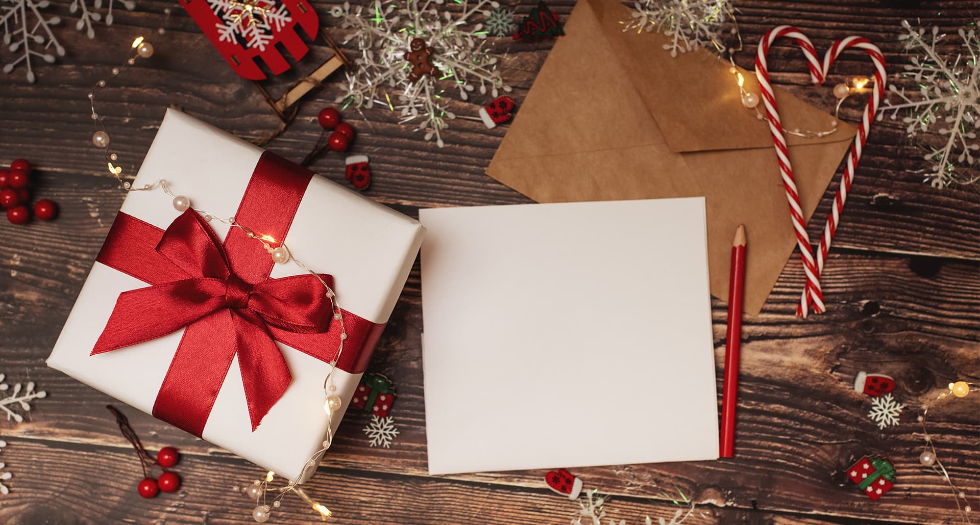 holiday-quotes: a present, a letter, and two candy canes under a tree.