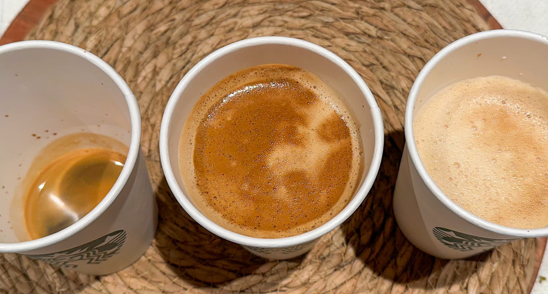 An overhead image of three Starbucks coffee drinks with the cortado in the middle.
