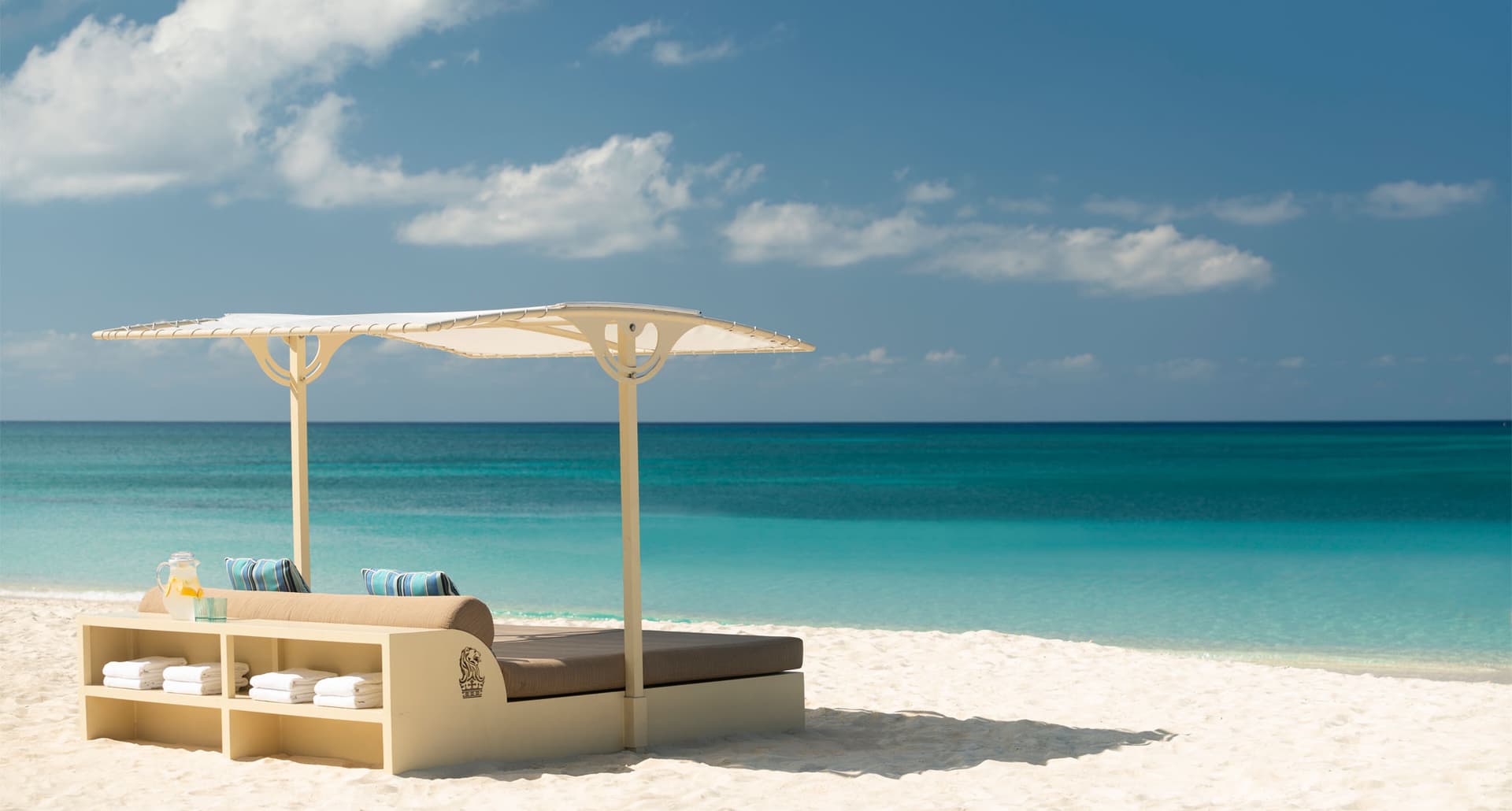 Nonstop Flights from Dallas - A photo of a umbrella covered cabana on a white sand beach with a bright blue sky.