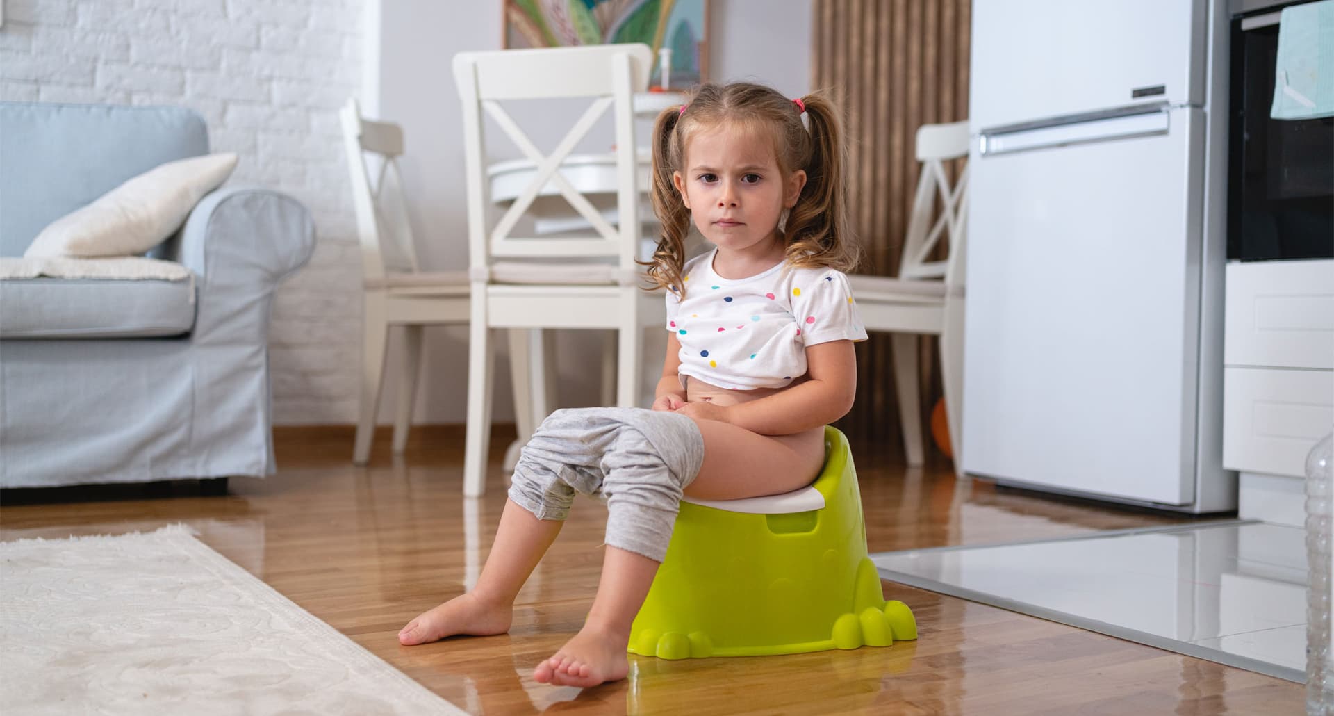 how-often-should-kids-poop: Portrait of toddler girl on a potty at the living room.