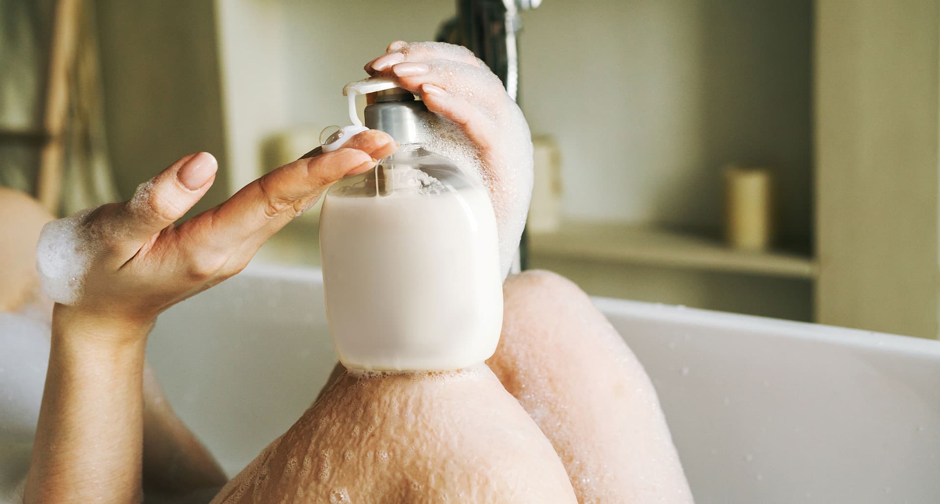 best feminine wash products a close up photo of a woman's hand and a bottle in a tub