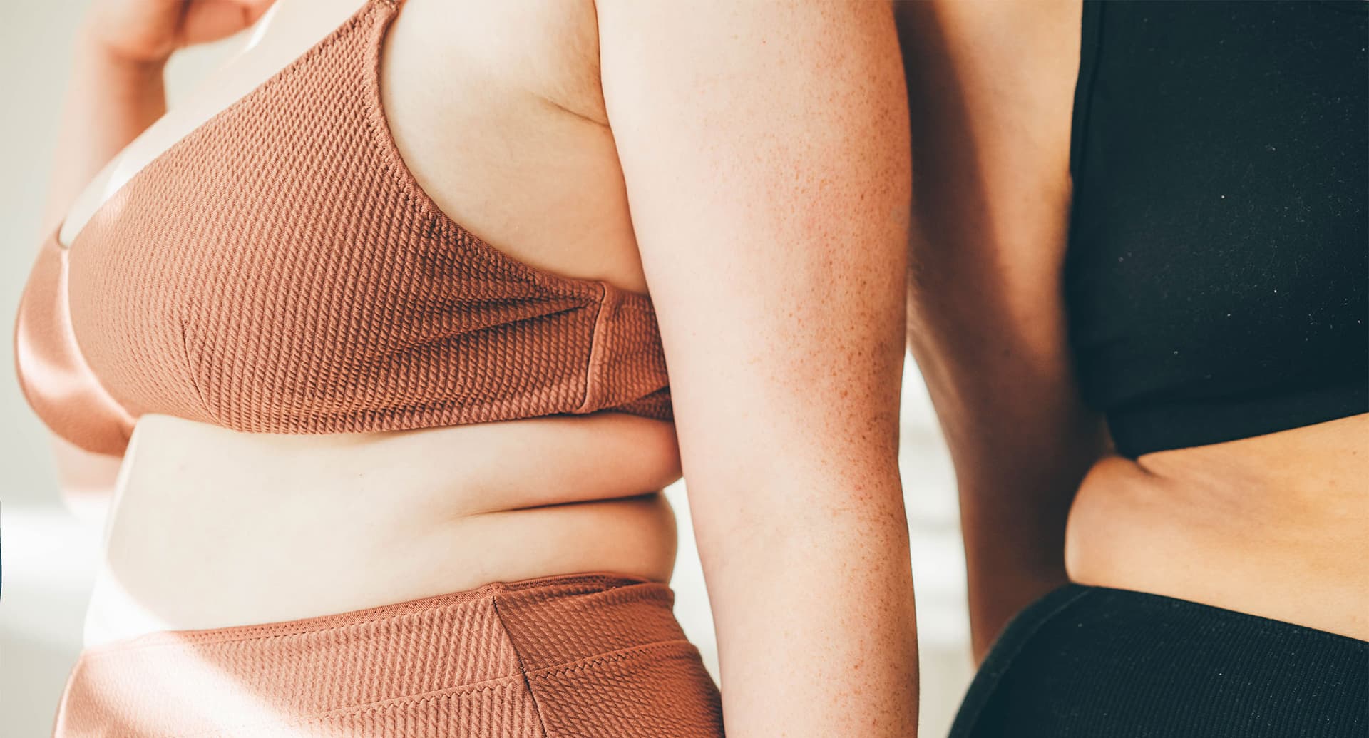 close up of two womens' torsos in bras and underwear