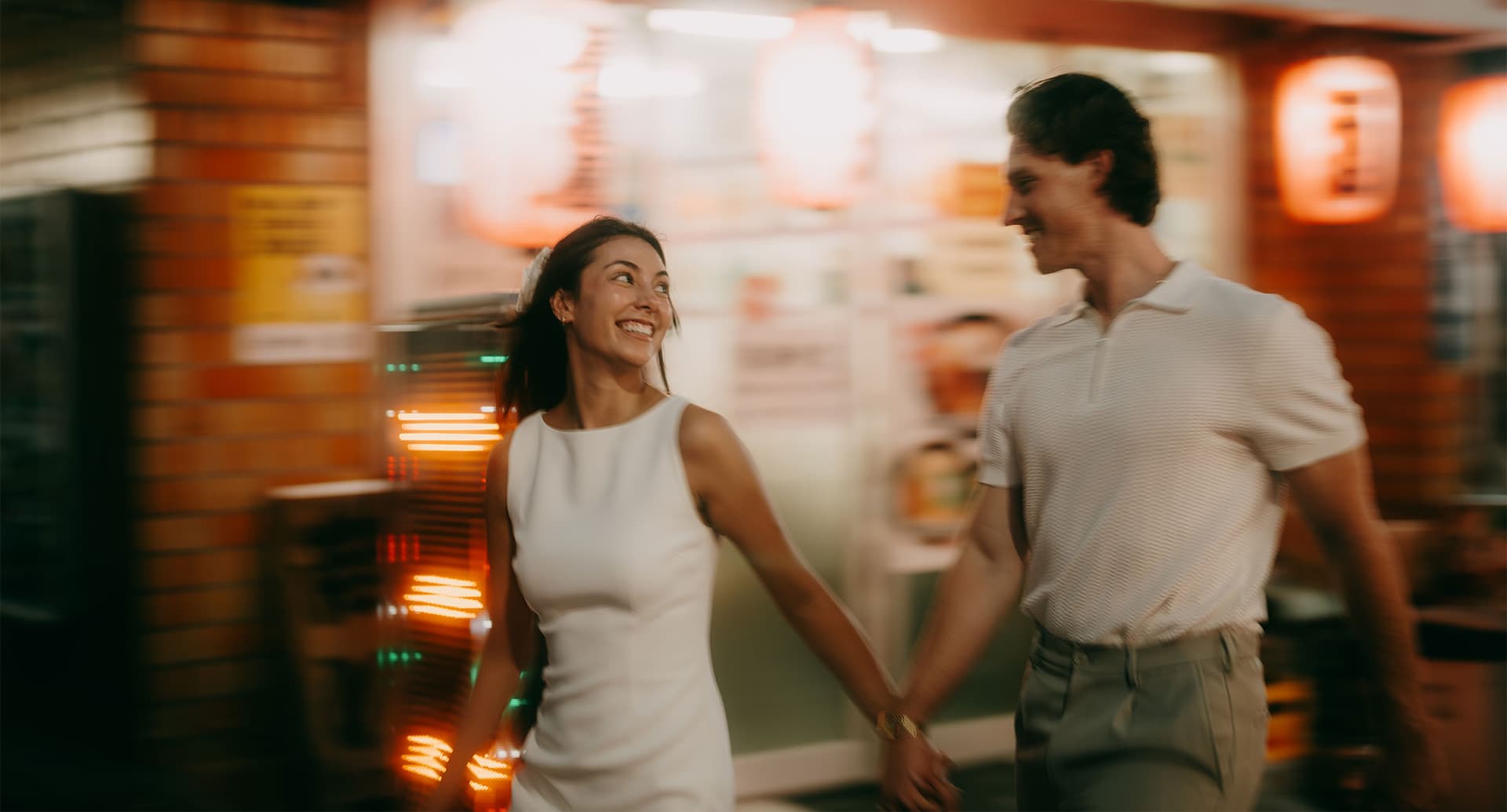 photo of a man and woman holding hands and smiling