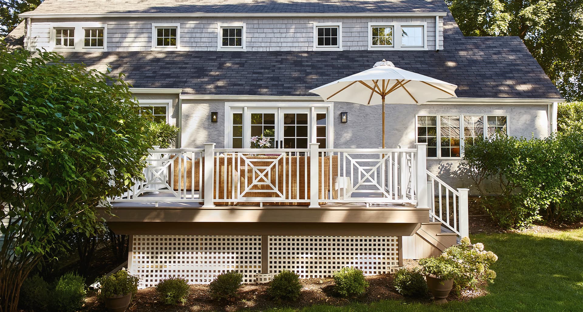 before-and-after-deck-renovation: a modern white deck with patio furniture