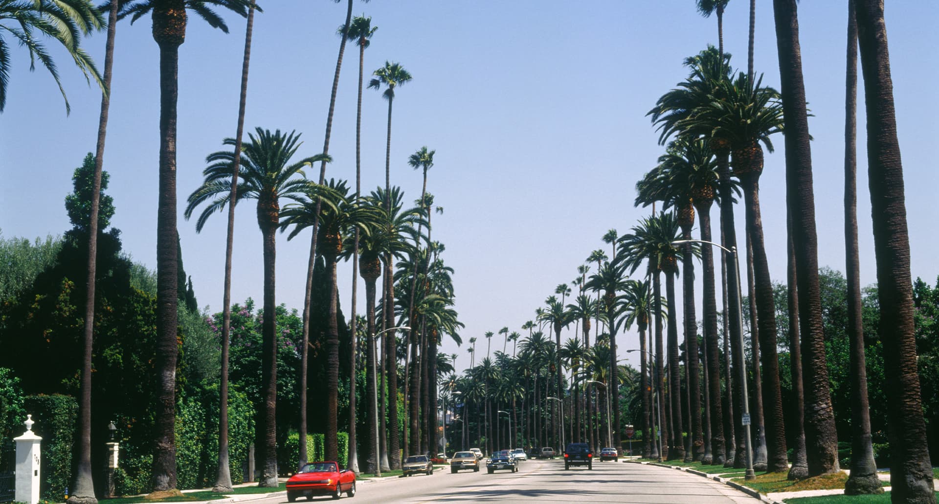 things-to-do-in-beverly-hills: cars driving down a street in beverly hills.