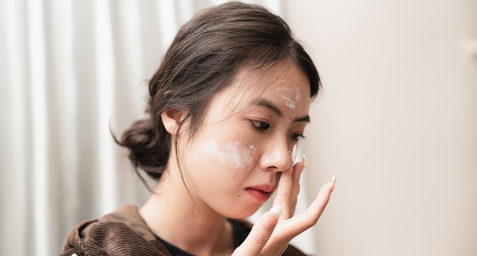 Why Does My Sunscreen Pill? And How To Prevent It Universal: a woman applying sunscreen to her face
