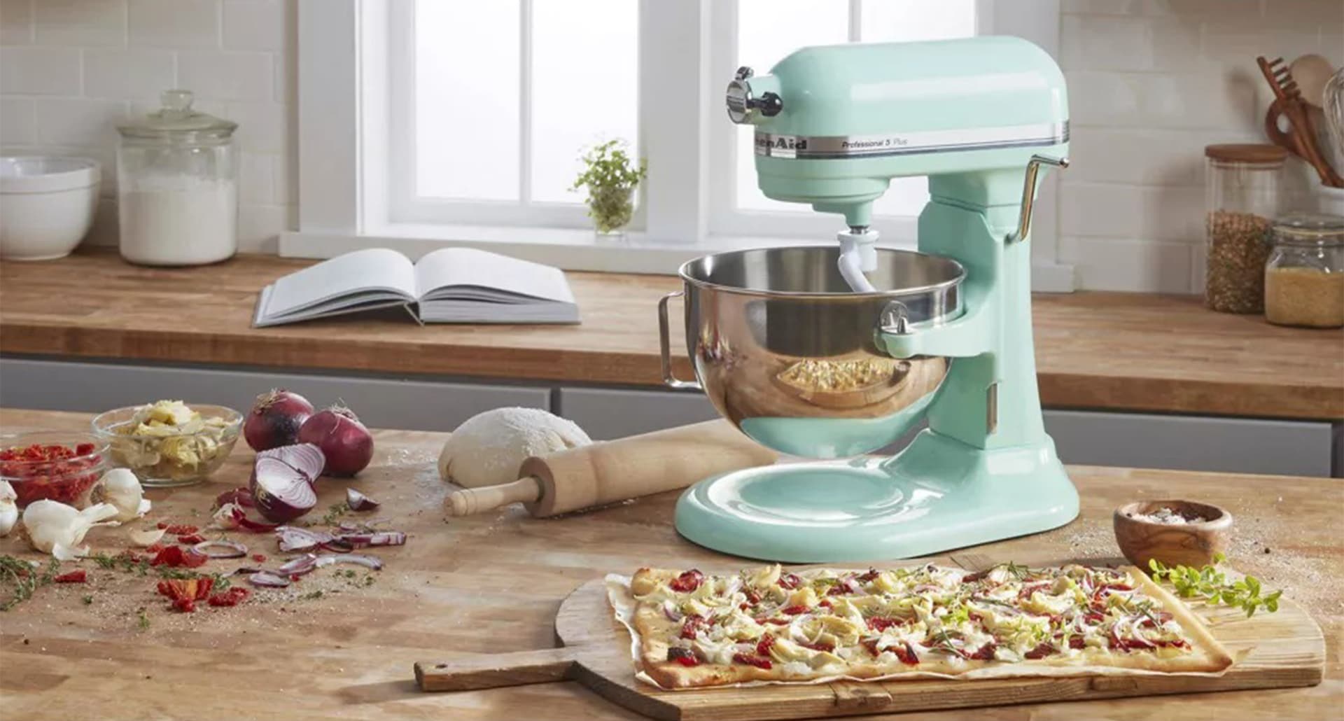 A close up of the KitchenAid Professional 5 quart mixer in teal sitting on a kitchen counter.