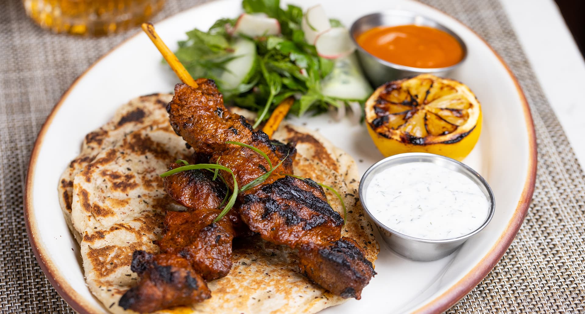 Solo Dining in Los Angeles: Plate of roasted pork belly on skewers with roasted lemon, dipping sauce and a side salad at Soulmate