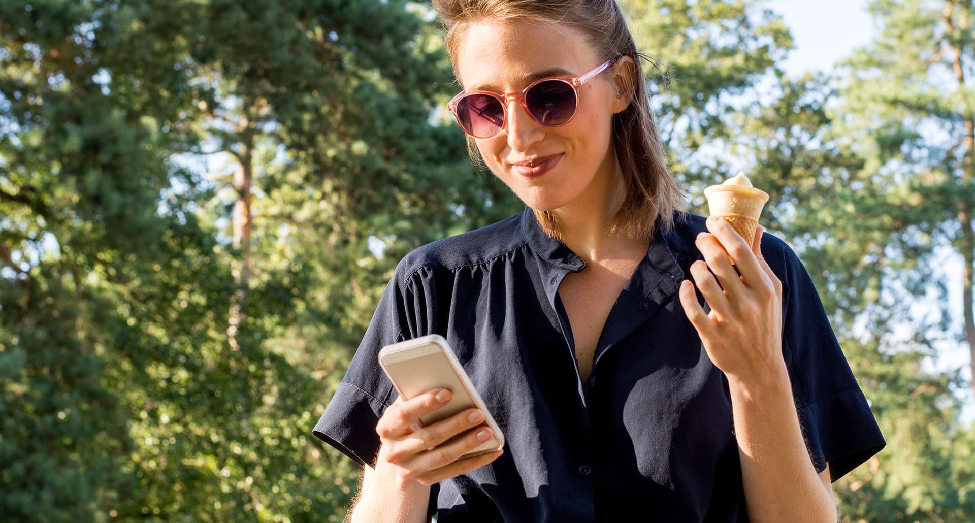 woman eating ice cream looking at her phone