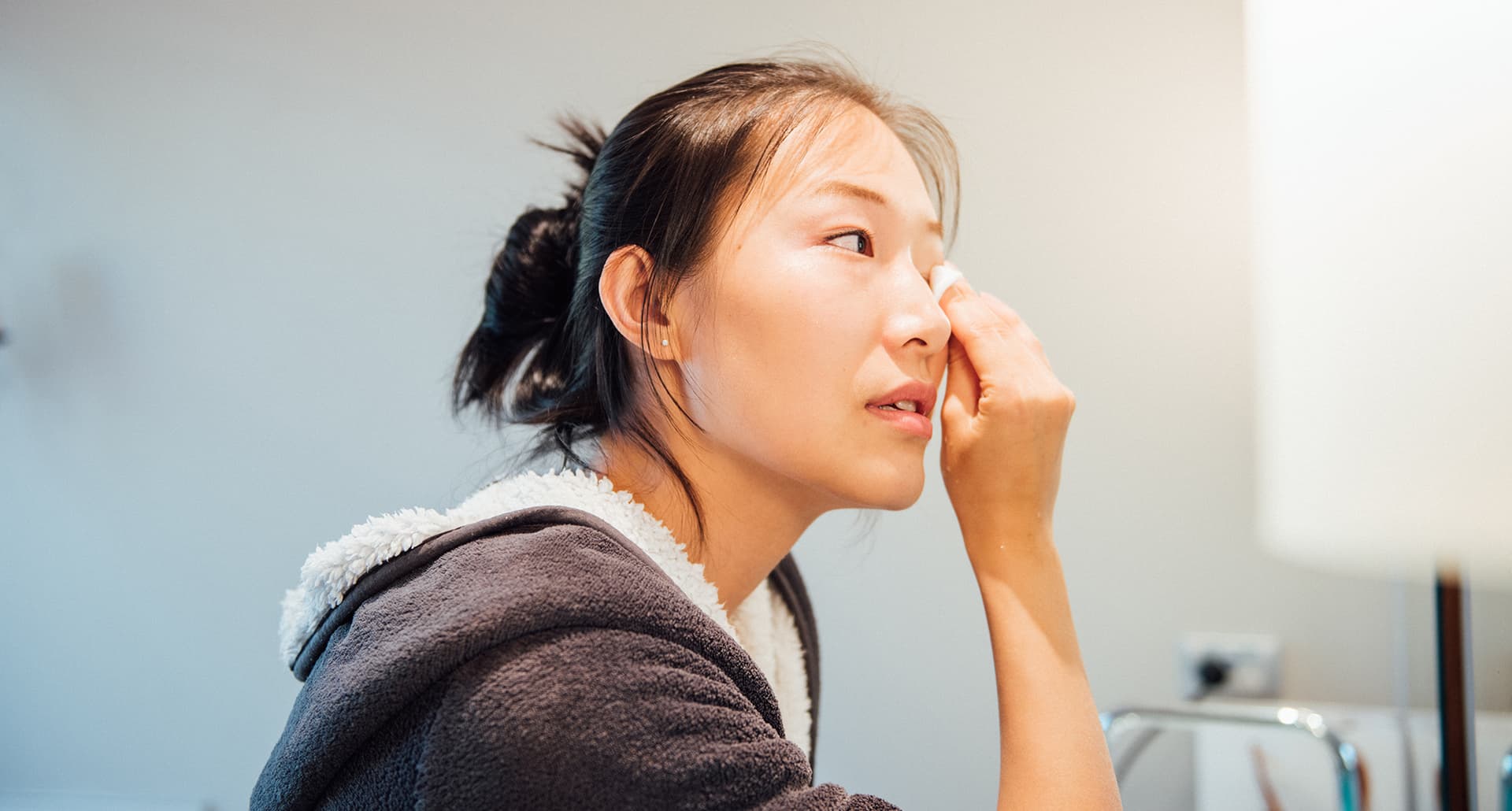 best makeup remover: a woman wiping off makeup from her eyes