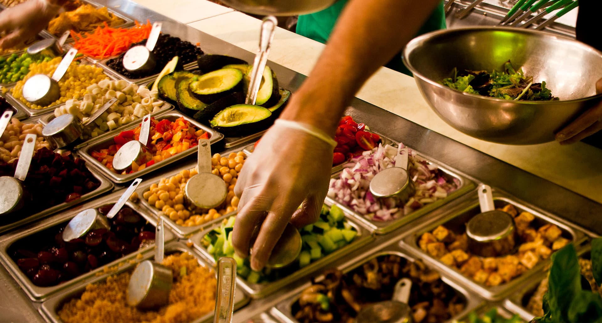 keto at sweetgreen: a hand reaching for chopped vegetables behind the counter at sweetgreen